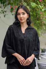 Woman wearing a black embroidered top 